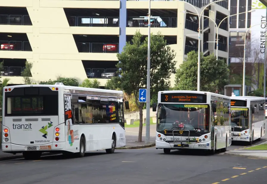 Photo showing three buses next to a carpark building in New Plymouth